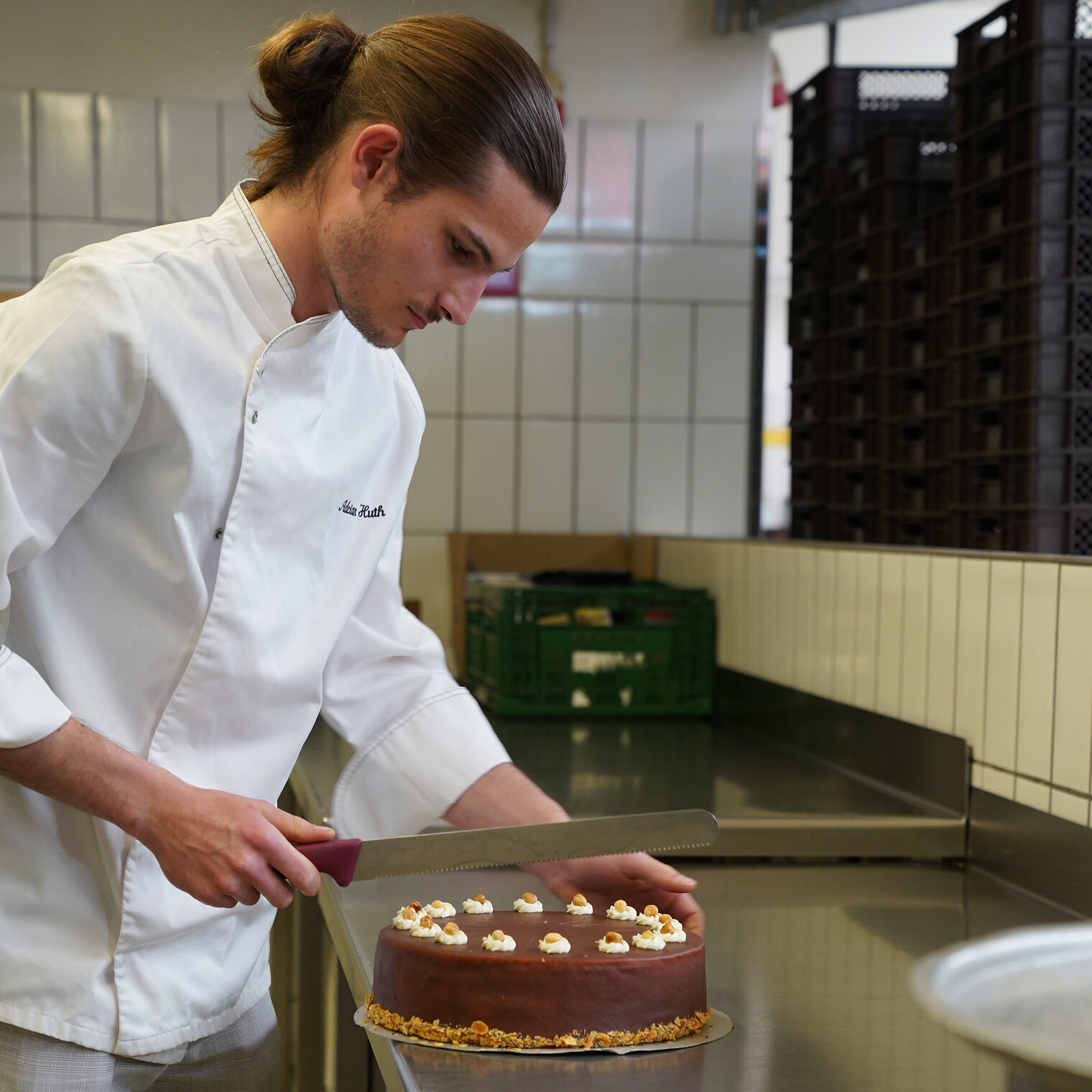 Adrian Huth, Meister im Konditorenhandwerk, schneidet eine Torte an.