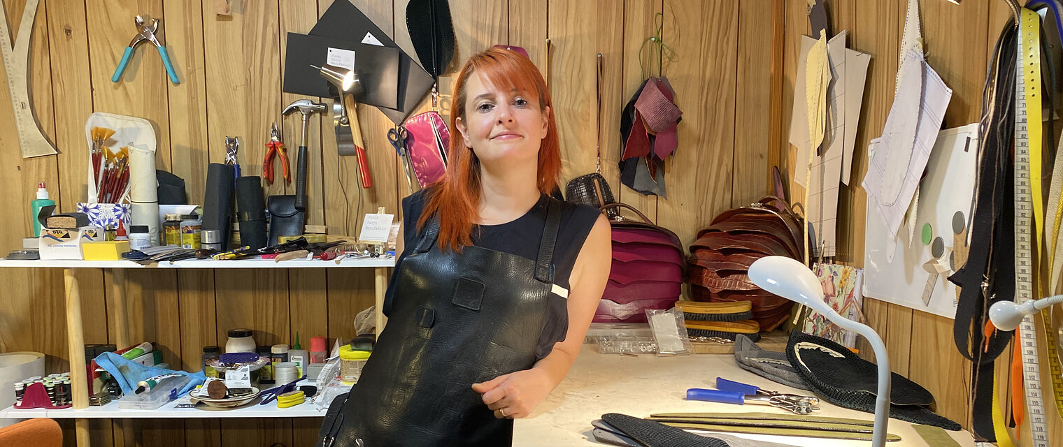 Funda Tanjo steht in ihrer Werkstatt umgeben von Materialien, die sie für Ihre Kreationen benötigt. 