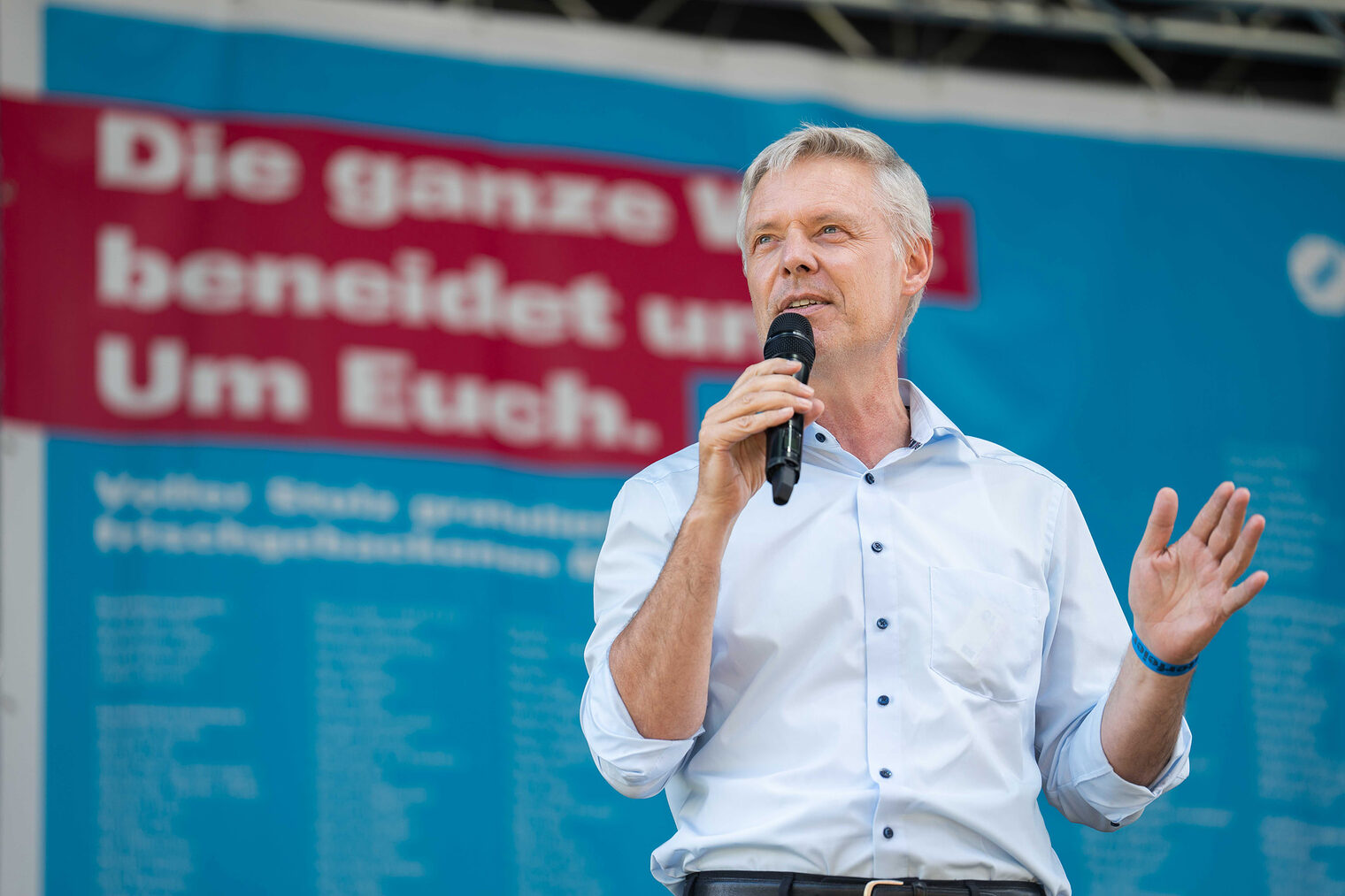 Staatssekretär Dr. Lösel ist Festredner bei der Meisterfeier 2022 und bewegt sich frei auf der Bühne mit dem Mikrofon in der Hand.