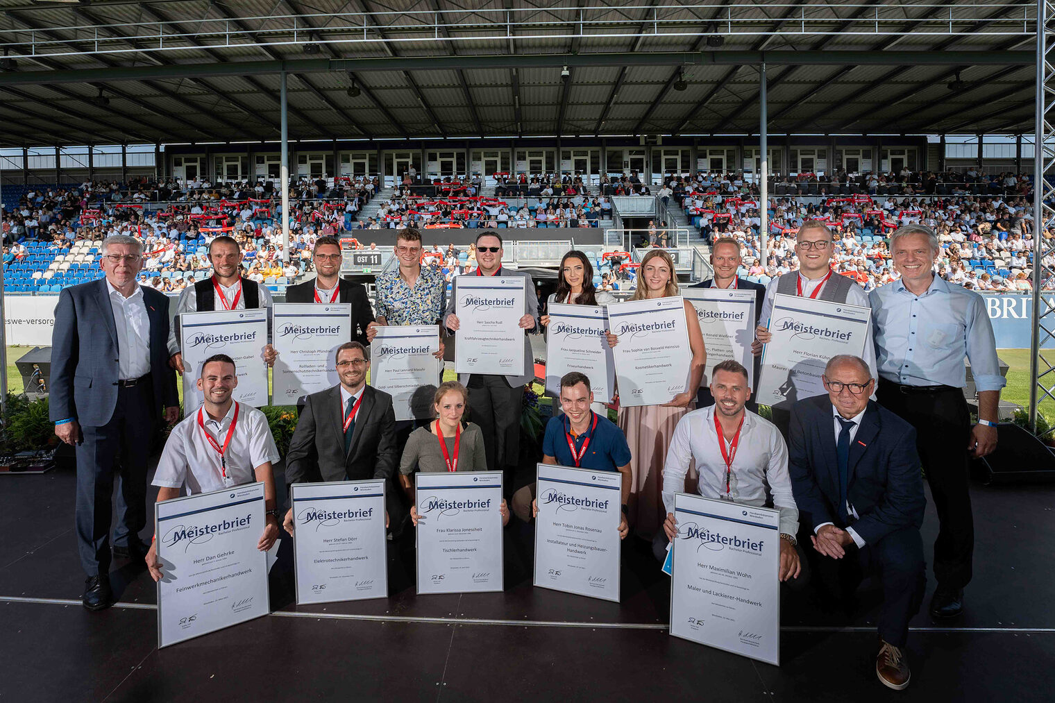 Gruppenbild der Jahrgangsbesten Meister 2021auf der Meisterfeier im Juli 2022 in der BRITA Arena auf der Bühne, stellvertretend für alle Meister.