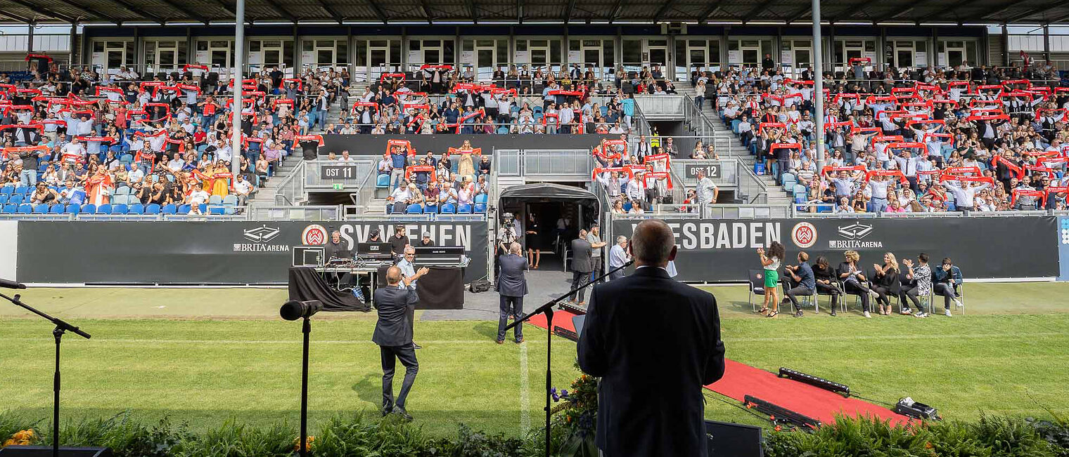 Blick auf die Tribüne mit allen geehrten Jungmeister/innen Blick auf die Tribüne auf der sich alle Jungmeister und Jungmeisterinnen mit ihrem Meisterschal erhoben haben.