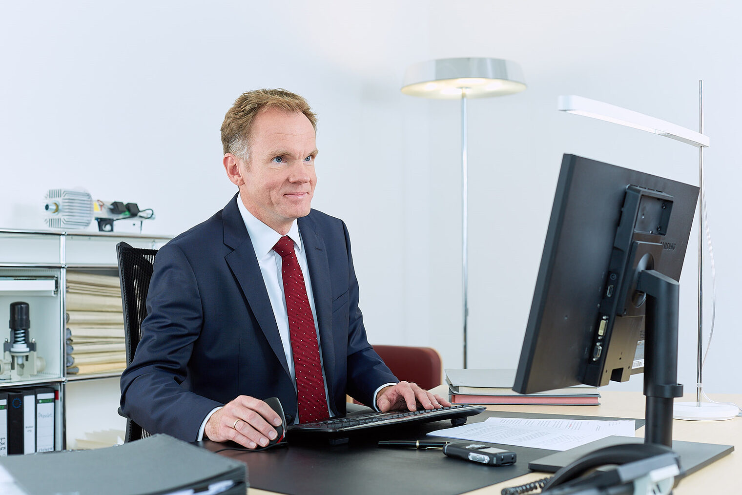 Dr. Siebert sitzt an seinem Schreibtisch und blickt auf seinen Bildschirm.