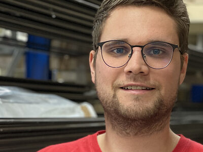 Christoph Pfündner, Meister im Rollladen- und Sonnenschutztechnikerhandwerk in seinem Lager mit einem Rollladen unter dem Arm.