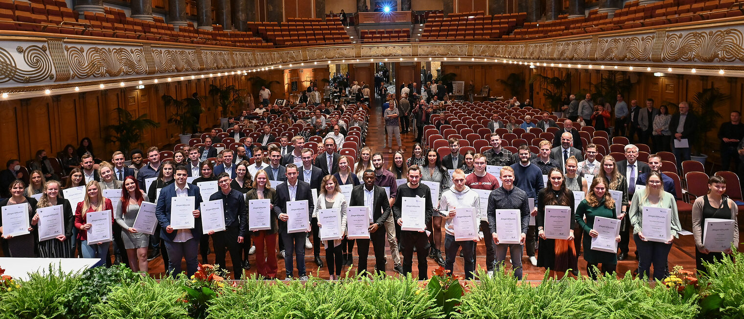 Der Hessische Handwerkstag (HHT) hat im Kurhaus der Landeshauptstadt Wiesbaden die besten Nachwuchshandwerkerinnen und Nachwuchshandwerker Hessens ausgezeichnet. Die jahrgangsbesten Gesellinnen und Gesellen stehen mit Ihren Siegerurkunden für ein Gruppenbild vor der Bühne im Kurhaus Wiesbaden. 