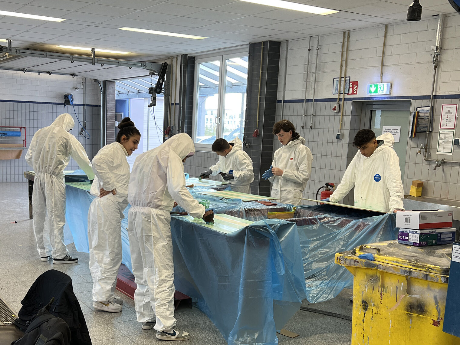 Die Schüler und Schülerinnen sind während ihrer Berufsorientierungswoche im Lehrgang zu Farb- und Lackiertechnik. Hier probieren sie verschiedene Lackiertechniken in der Lackierwerkstatt aus. 