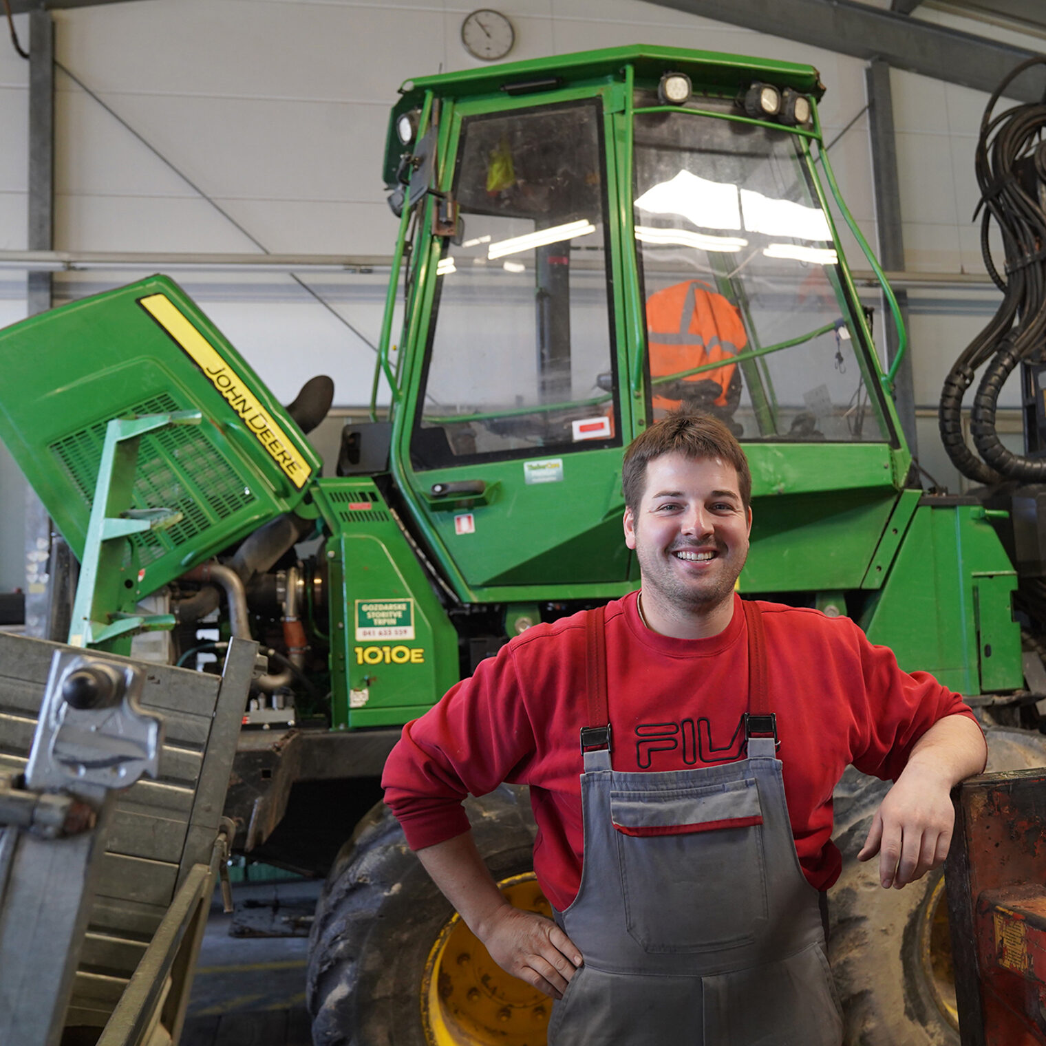 Markus Grosch, Land- und Baumaschinenmechatronikermeister, in der Werkstatt der Hans Grosch GmbH & Co. KG in Kemel. Er steht vor einer großen Landmaschine. 