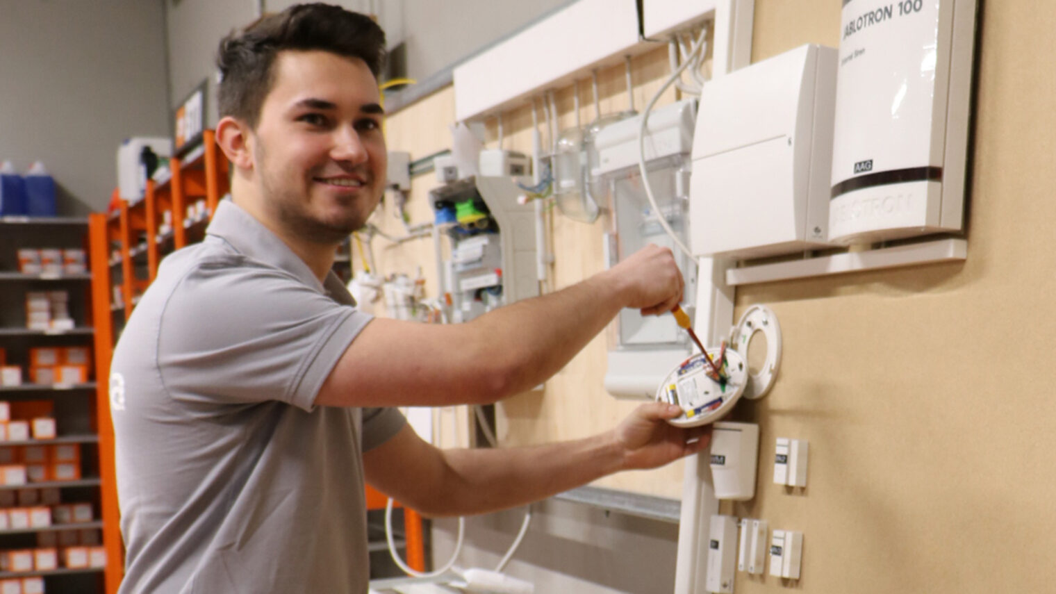 Profilbild eines jungen Mannes der an einer Elektroinstallationswand arbeitet.