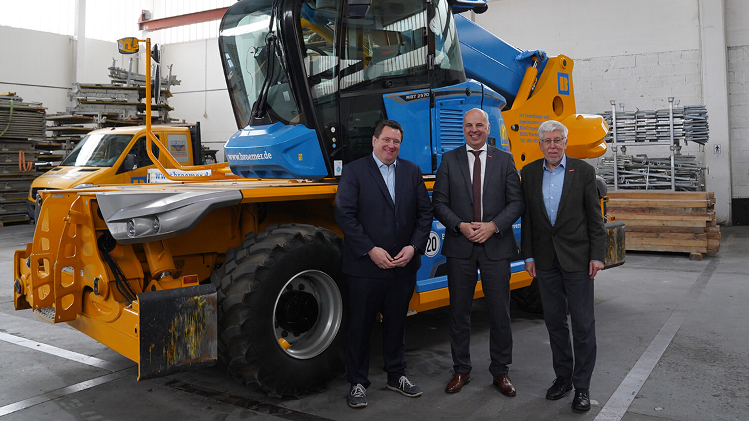 Bauunternehmer Jörg Brömer, Kammerpräsident Stefan Füll und Kammer-Hauptgeschäftsführer Bernhard Mundschenk stehend vor einem Baukran.