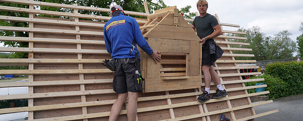 Zwei junge Männer arbeiten an einem Modell-Dach.