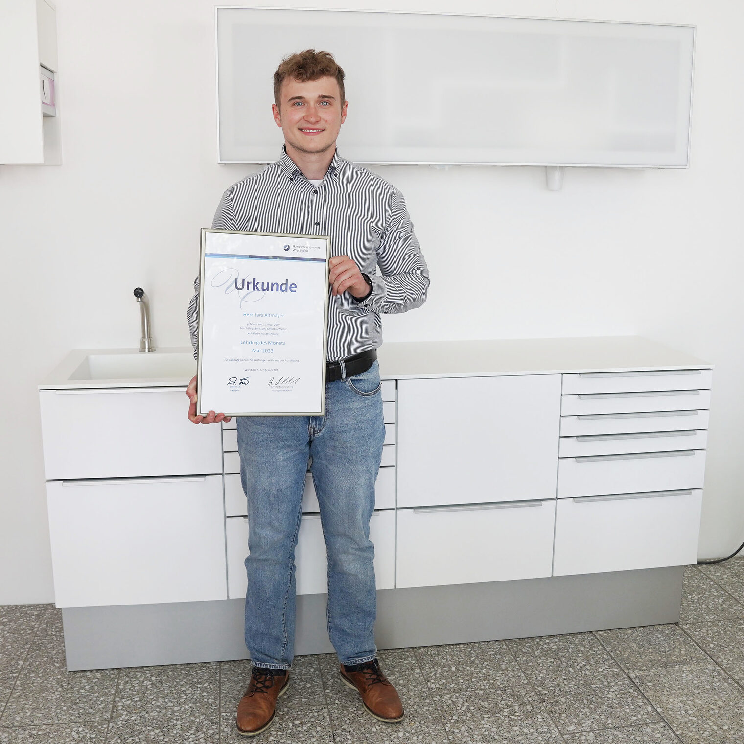 Lehrling des Monats Mai 2023 Lars Altmayer, vor einem von der Aligni GmbH produzierten Zahnartztmöbel.