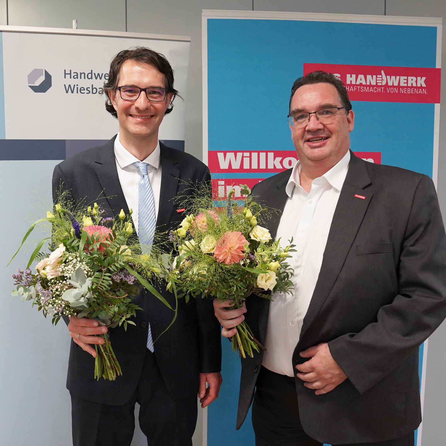 Bei der Vollversammlung wurde Dr. Christoph Gelking, Geschäftsführer der Handwerkskammer Wiesbaden, einstimmig zum stellvertretenden Hauptgeschäftsführer als Nachfolger für Dr. Martin Pott gewählt. Matthias Schober, Hauptabteilungsleiter Organisation und Recht, wurde geschlossen zum Geschäftsführer gewählt. Dr. Gelking und Schober bekleiden ihre neuen Positionen zum 1. Februar 2024. Beide sind mit einem Blumenstrauß auf dem Bild zu sehen. 