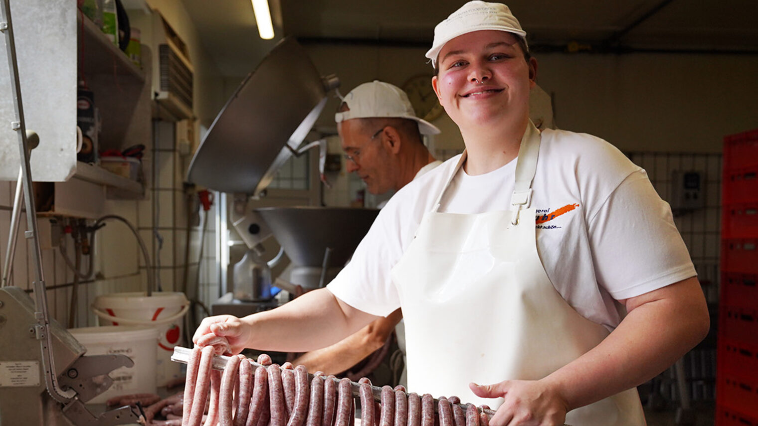 Nahaufnahme vom Lehrling des Monats Georgina Martin bei der Verarbeitung von Würsten.