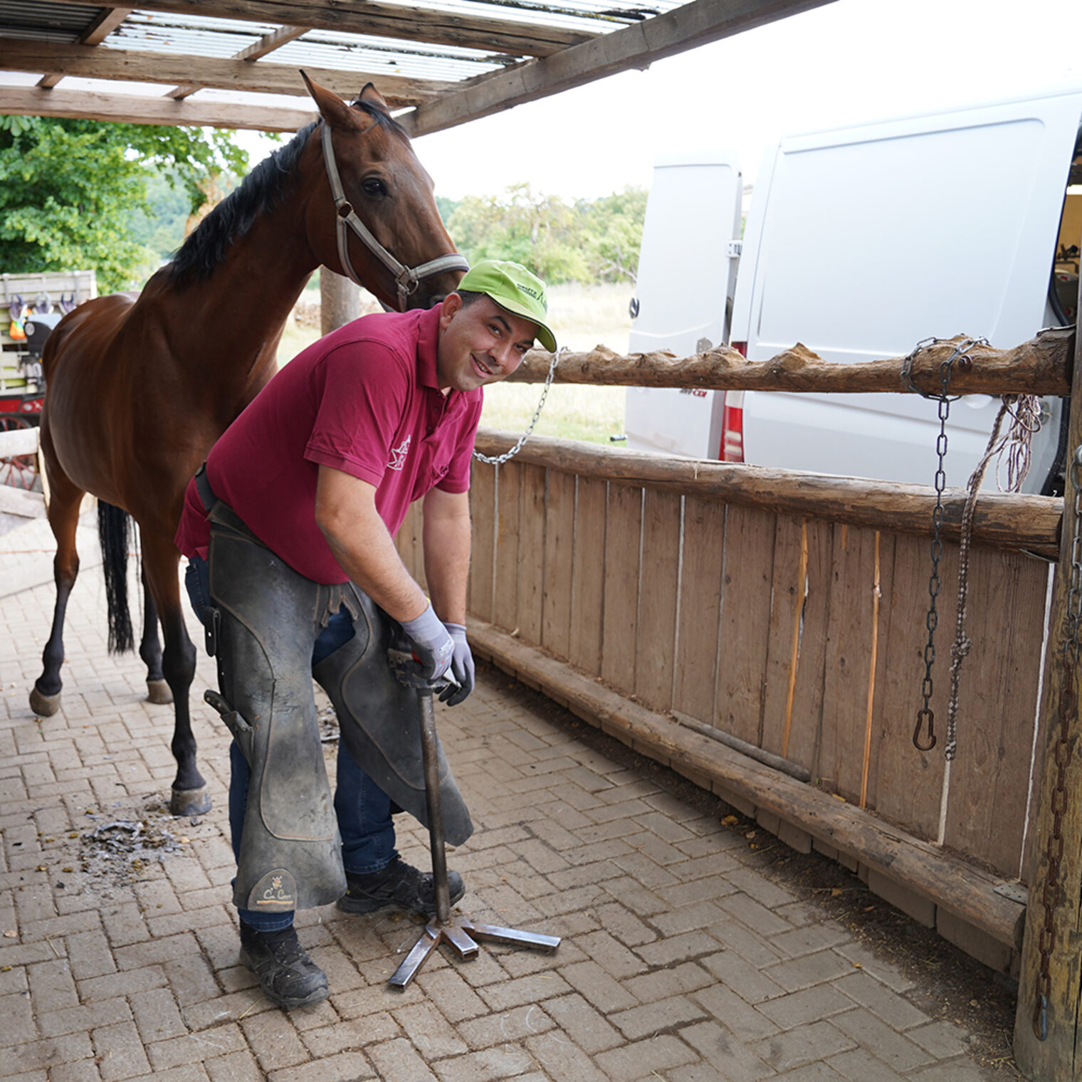 Philipp Striebinger bei der Arbeit mit einem Pferd in einer Stallgasse neben seinem Transporter