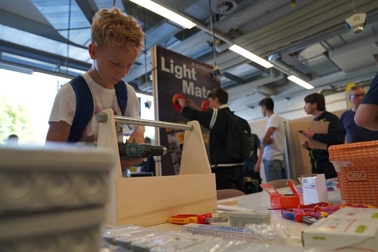 Aktionsbilder von der Veranstaltung "Handwerk live" 2023 in Wiesbaden. In den offenen Werkstätten konnten sich Jugendliche über das Handwerk informieren, sich ausprobieren und Kontakte knüpfen. Die Bilder zeigen verschiedene Jugendliche in und um das Berufsbildungs- und Technologiezentrum in Wiesbaden am Tag des Handwerks. 