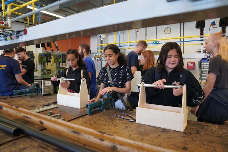 Aktionsbilder von der Veranstaltung "Handwerk live" 2023 in Wiesbaden. In den offenen Werkstätten konnten sich Jugendliche über das Handwerk informieren, sich ausprobieren und Kontakte knüpfen. Die Bilder zeigen verschiedene Jugendliche in und um das Berufsbildungs- und Technologiezentrum in Wiesbaden am Tag des Handwerks. 