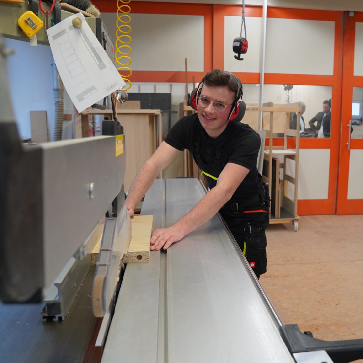 Fabian Klein in der Werkstatt an der Säge seines Ausbildungsbetriebes Christ & Holtmann Werkstätte für Innenausbau GmbH.