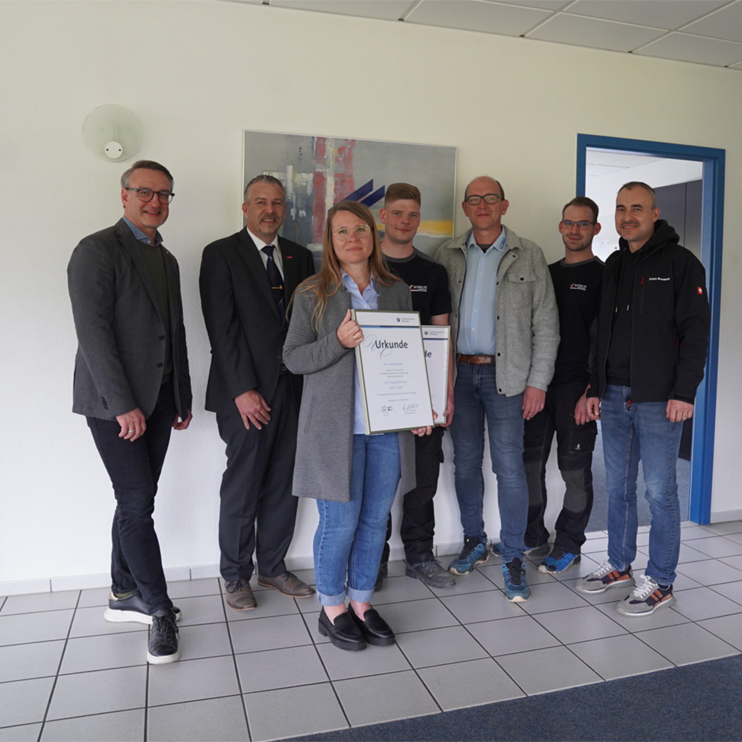 Gruppenbild: von links nach rechts sind zu sehen Stv. Kreishandwerksmeister Stefan Zienert, Kammervizepräsident Andreas Brieske, Büroleiterin der Schulte Weiss GmbH Mirjam Weiss, Lehrling des Monats Noah Becker, Geschäftsführer Heiko Weiss, Ausbilder Nicolas Beck und Assistent der Geschäftsführung Erkan Bozdemir von der Schulte Weiss GmbH