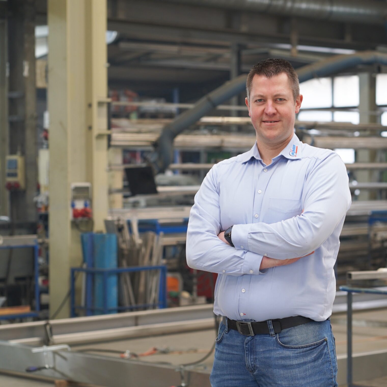David Iflinger mit verschränkten Armen in der Werkhalle seines Unternehmens.