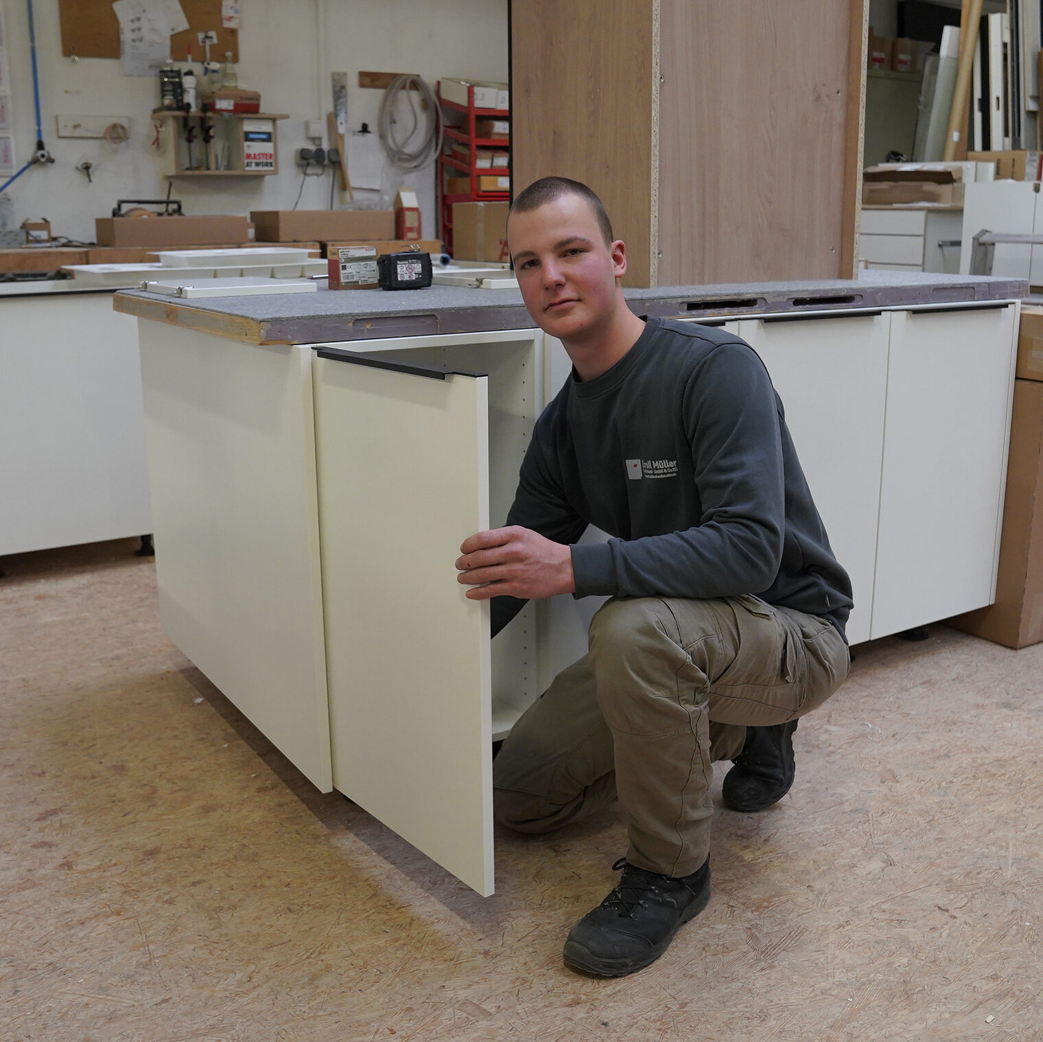 Lehrling des Monats Oliver Leibold bei der Montage eine kleinen Schranktür.