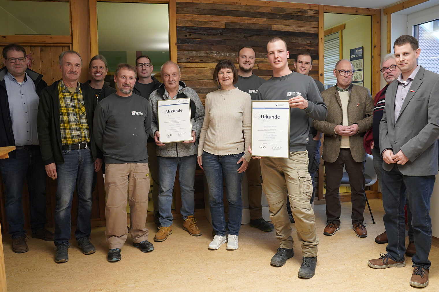 Lehrling des Monats Oliver Leibold vorne rechts mit Urkunde. Dahinter die Gruppe der Gratulantinnen und Gratulanten.