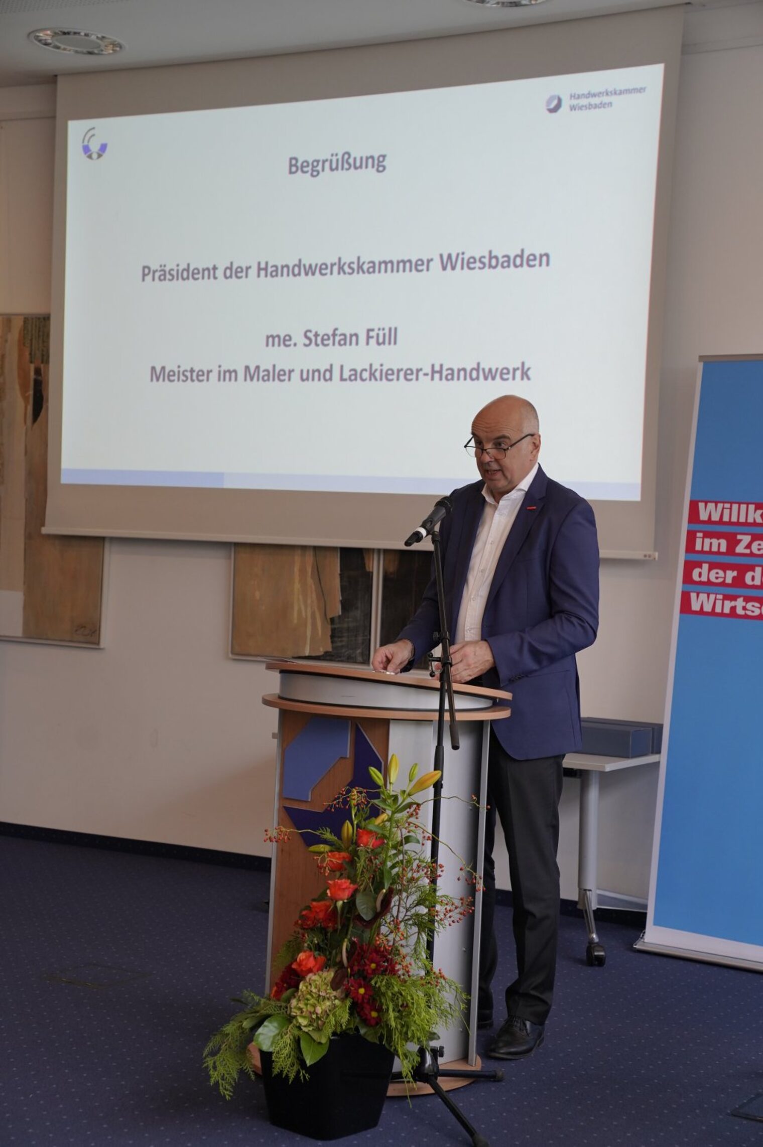 Der Präsident der Handwerkskammer Wiesbaden, Stefan Füll, am Rednerpult zur Begrüßung auf der Sachverständigentagung. 