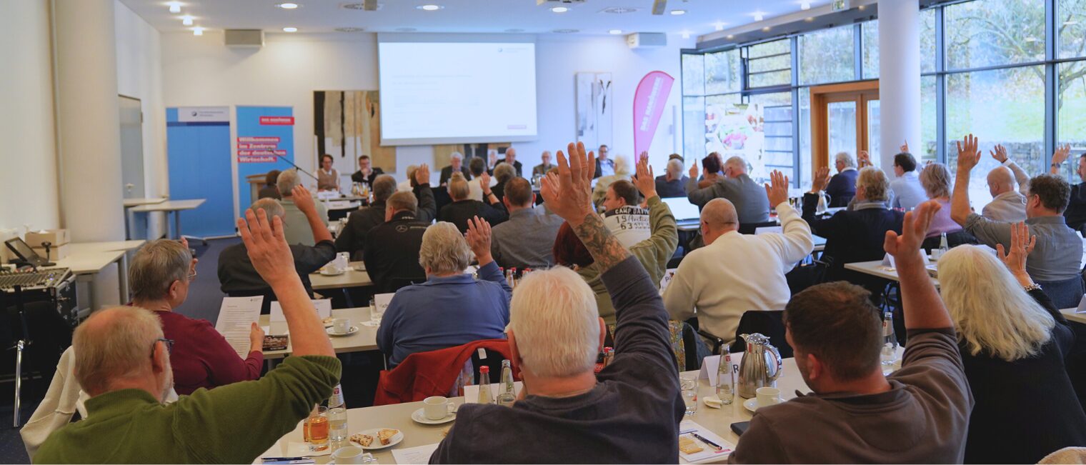Das Bild zeigt eine Abstimmung von hinten, während der Vollversammlung im Meistersaal der Handwerkskammer Wiesbaden.