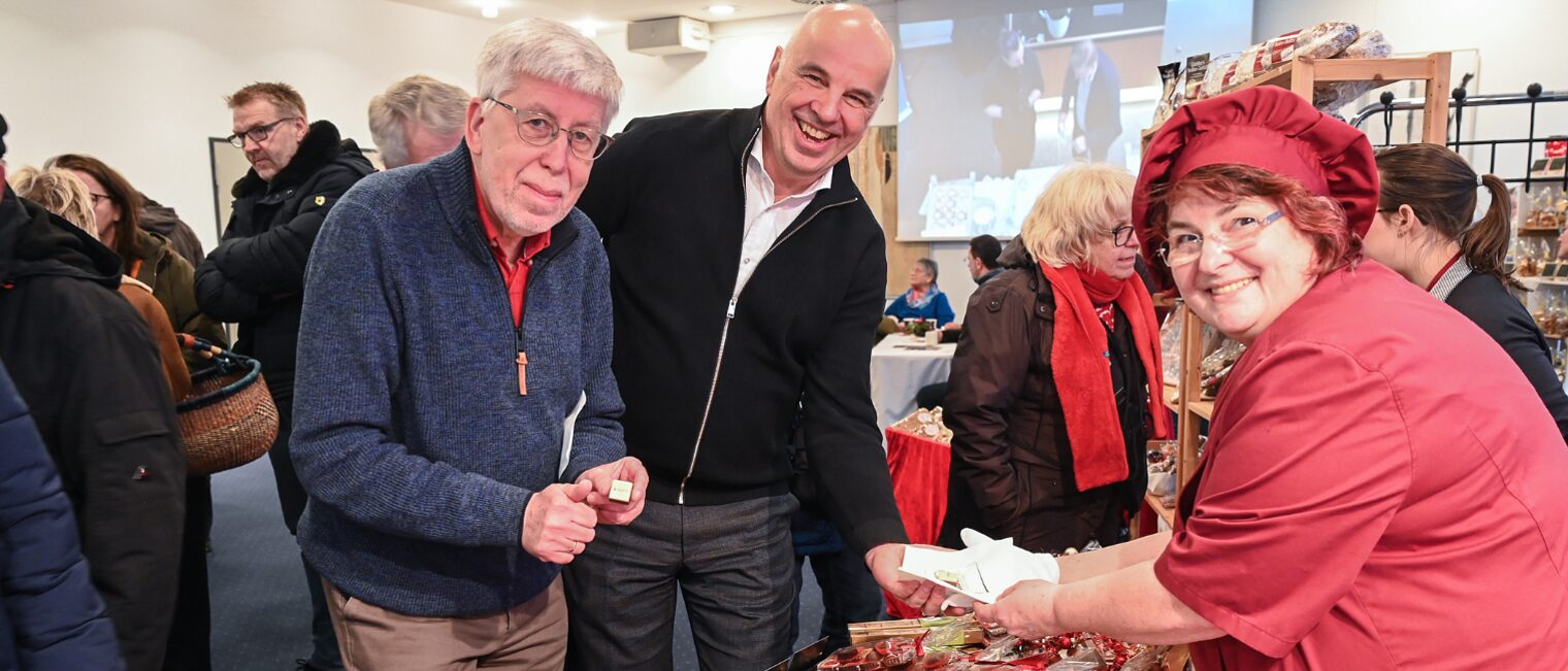Am Weihnachtsmarkt des Handwerks stehen Hauptgeschäftsführer Herr Mundschenk und Präsident Herr Füll mit Birgit Günther, Meisterin im Bäcker- sowie Konditorenhandwerk vor Ihrem Stand und bekommen Pralinen überreicht.