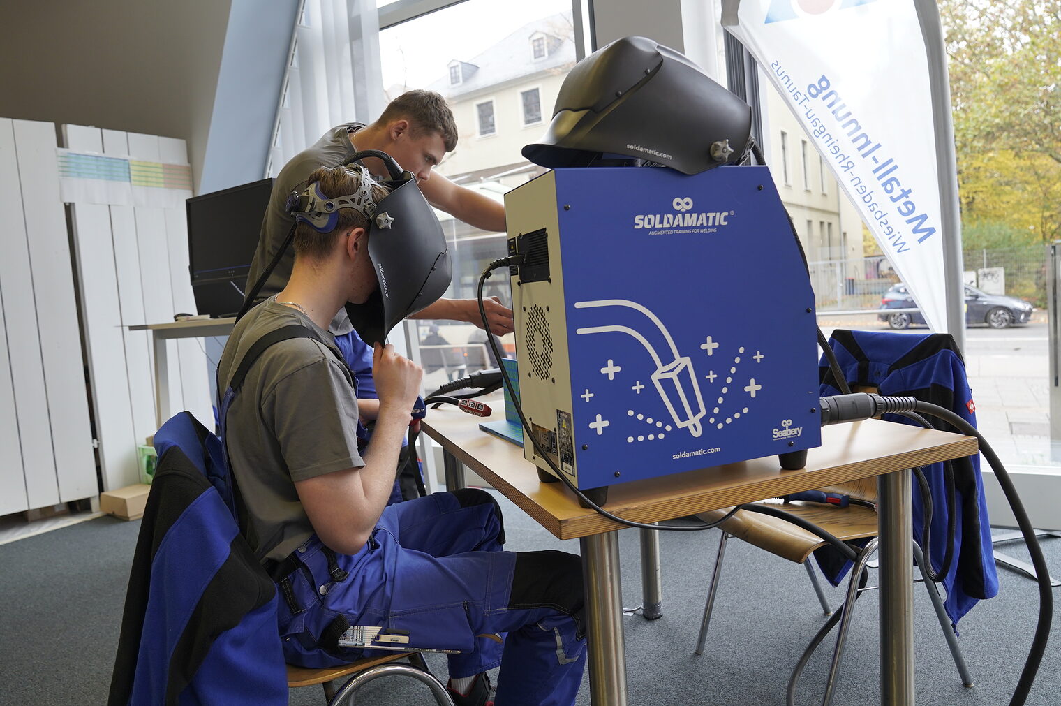 Zwei Junge Männer probieren sich an einem Schweißgerät.