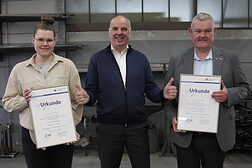 Lehrling des Monats Leonie Repp (mit Urkunde), Kammerpräsident Stefan Füll und Metallbauermeister Alexander Repp (mit Urkunde) stehen nebeneinander in der Werkstatthalle.