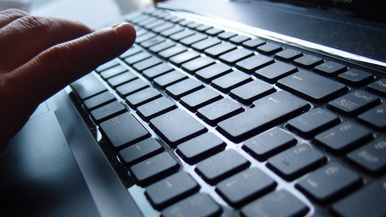 Hand an einer PC-Tastatur