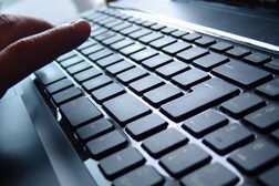 Hand an einer PC-Tastatur