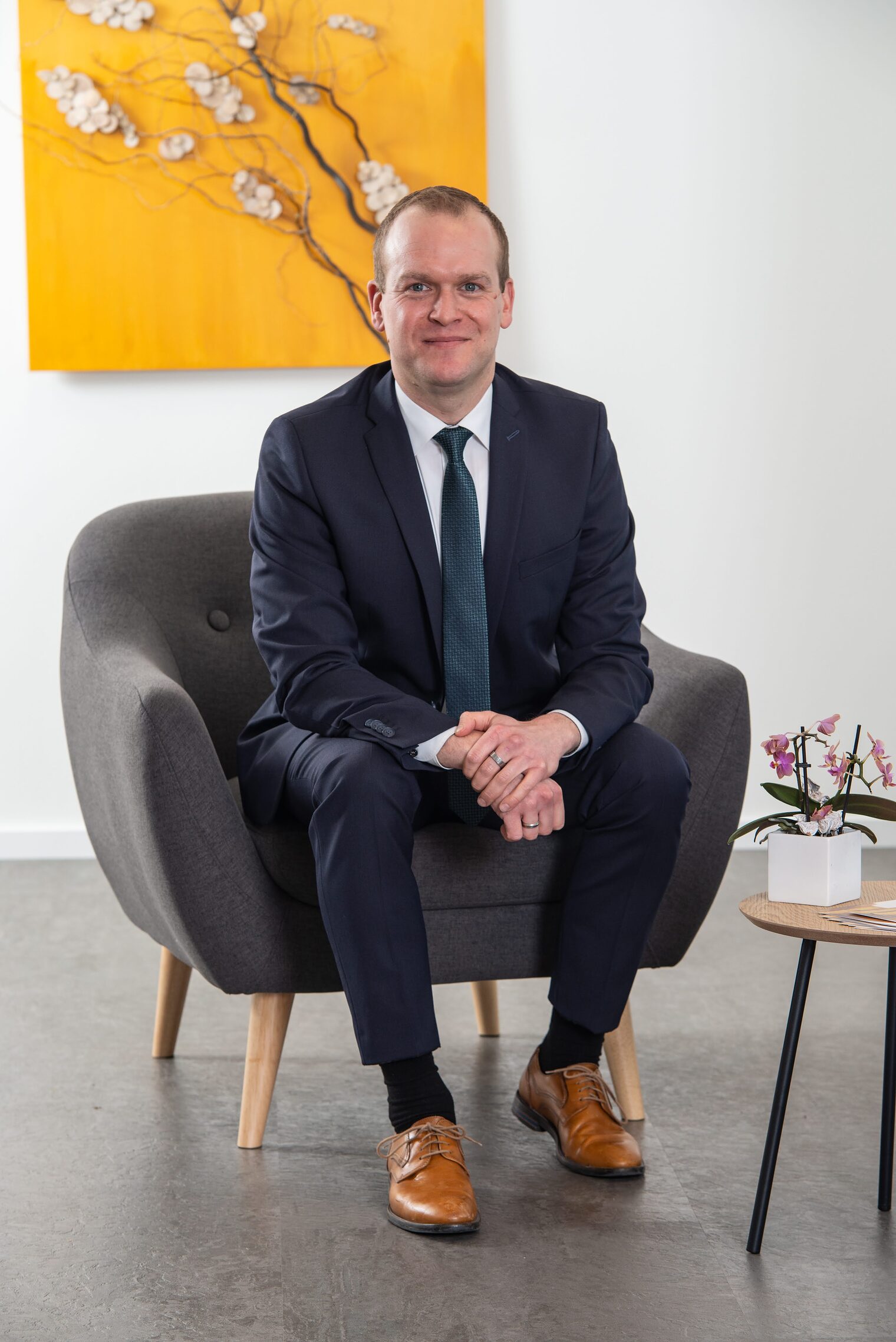 Benedikt Kirchberg in seinem Bestattungsunternehmen, sitzend auf einem Sessel.