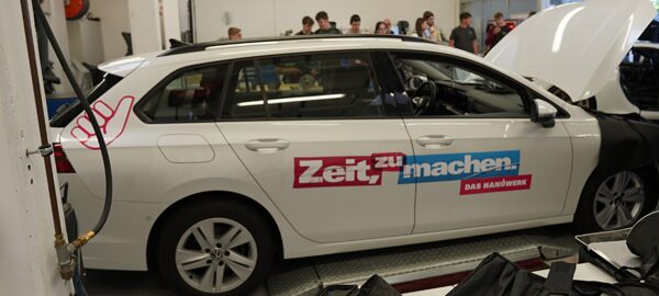 Ein Auto in der Kfz-Werkstatt auf dem "Zeit zu machen" steht.