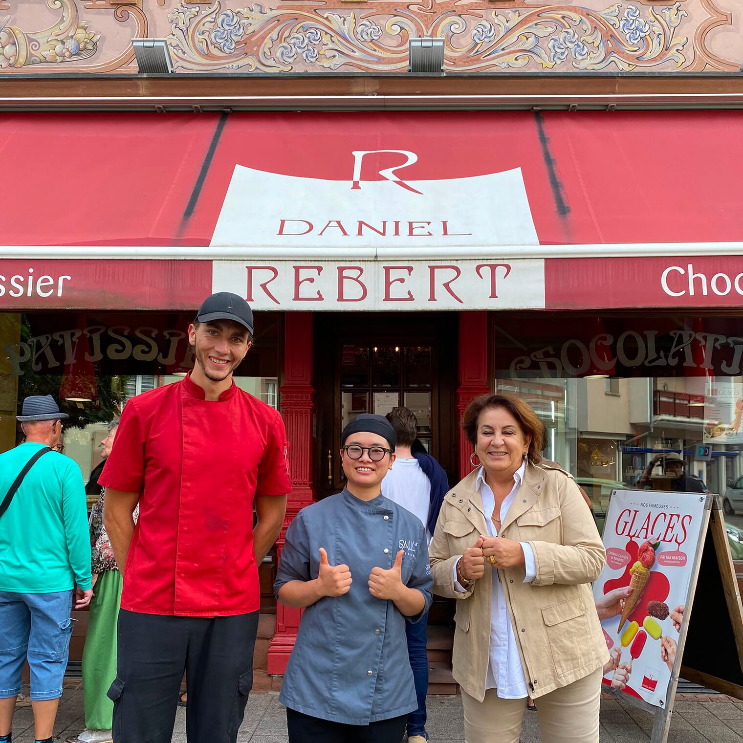 Inhaberin der Patisserie Isabelle Gauguet und mit dem Konditormeister und Leiter der Backstube Enzo Pinto mit Ihrer Praktikantin Thu Trang Dinh vor der Patisserie. 